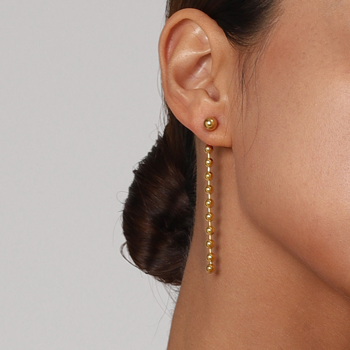 Gold stud with tail